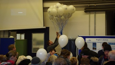 In der Warmhalle / Ballonhalle: Luftballone mit Postkarten, Papierraketenbau, Bewirtung - später Ballonstartvorbereitung.